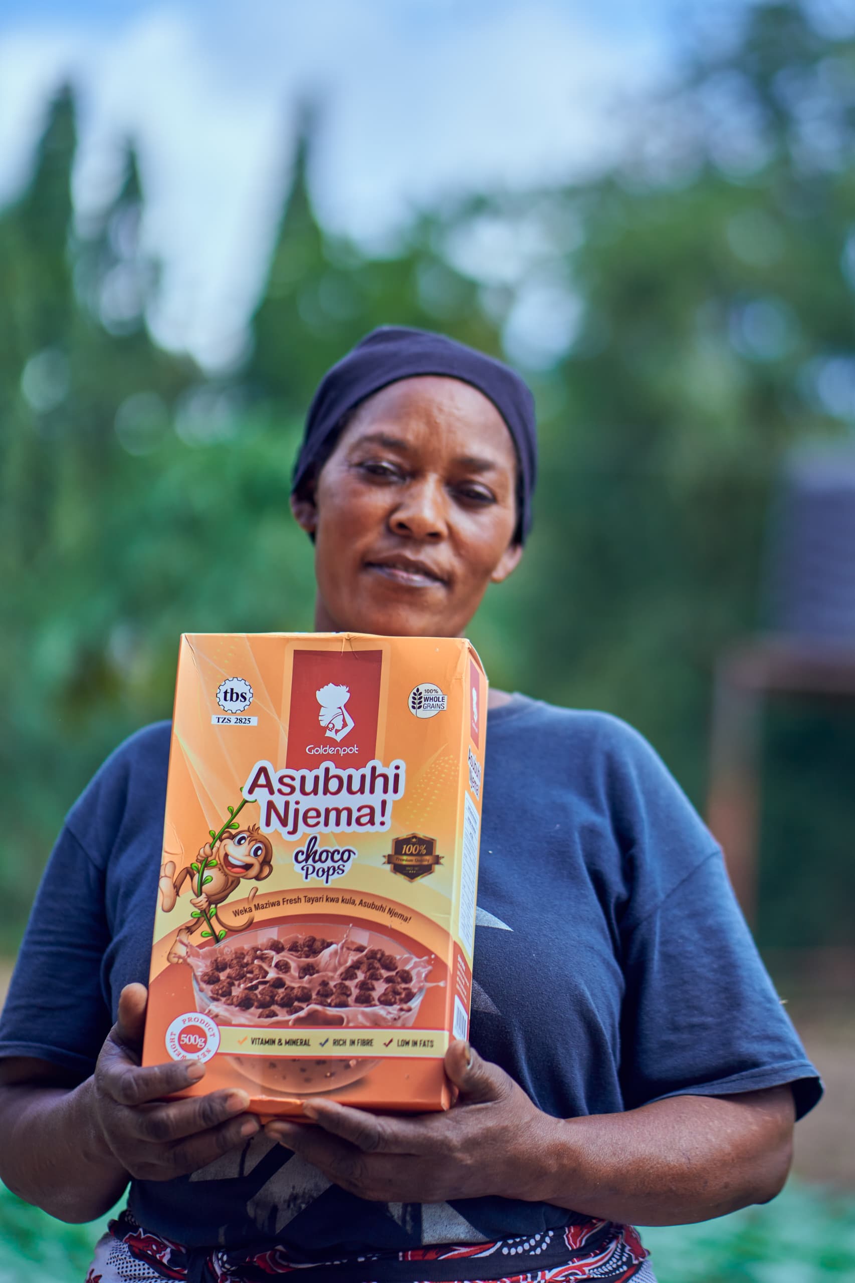 Woman holding Goldenpot Asubuhi Njema Choco Pops cereal